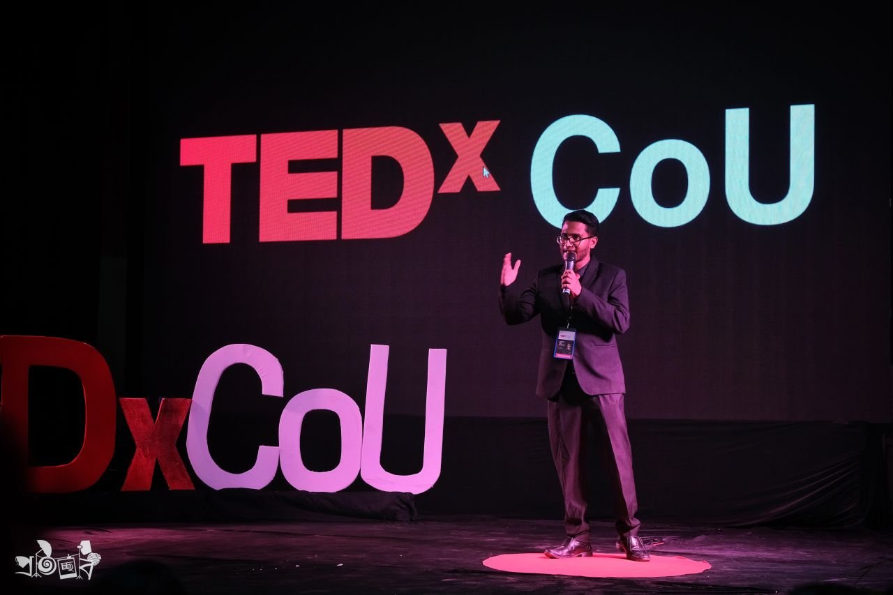 Speaking on stage at TEDx CoU